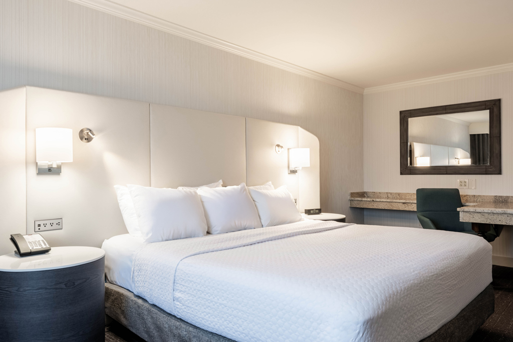 King hotel room with white bedding
